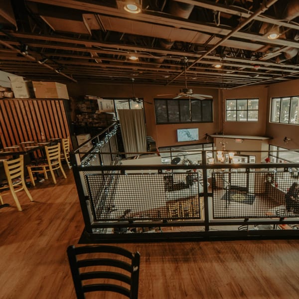 Overhead view of The Wayward Cafe's two-story interior with tables, chairs, and industrial decor.